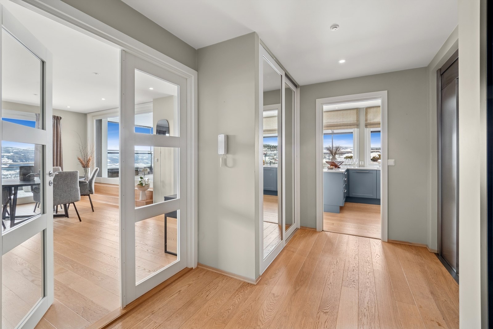 Heisen går opp i leiligheten og inn i en innbydende og romslig hall med god skyvedørsgarderobe med speildører. Galleribilde