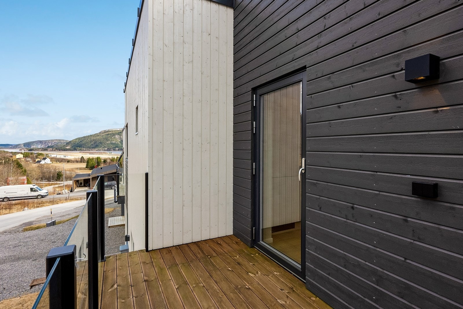 Terrasse med inngang til kjøkken på nordside av boligen. Utsikt øst og mot flyplassen. Galleribilde