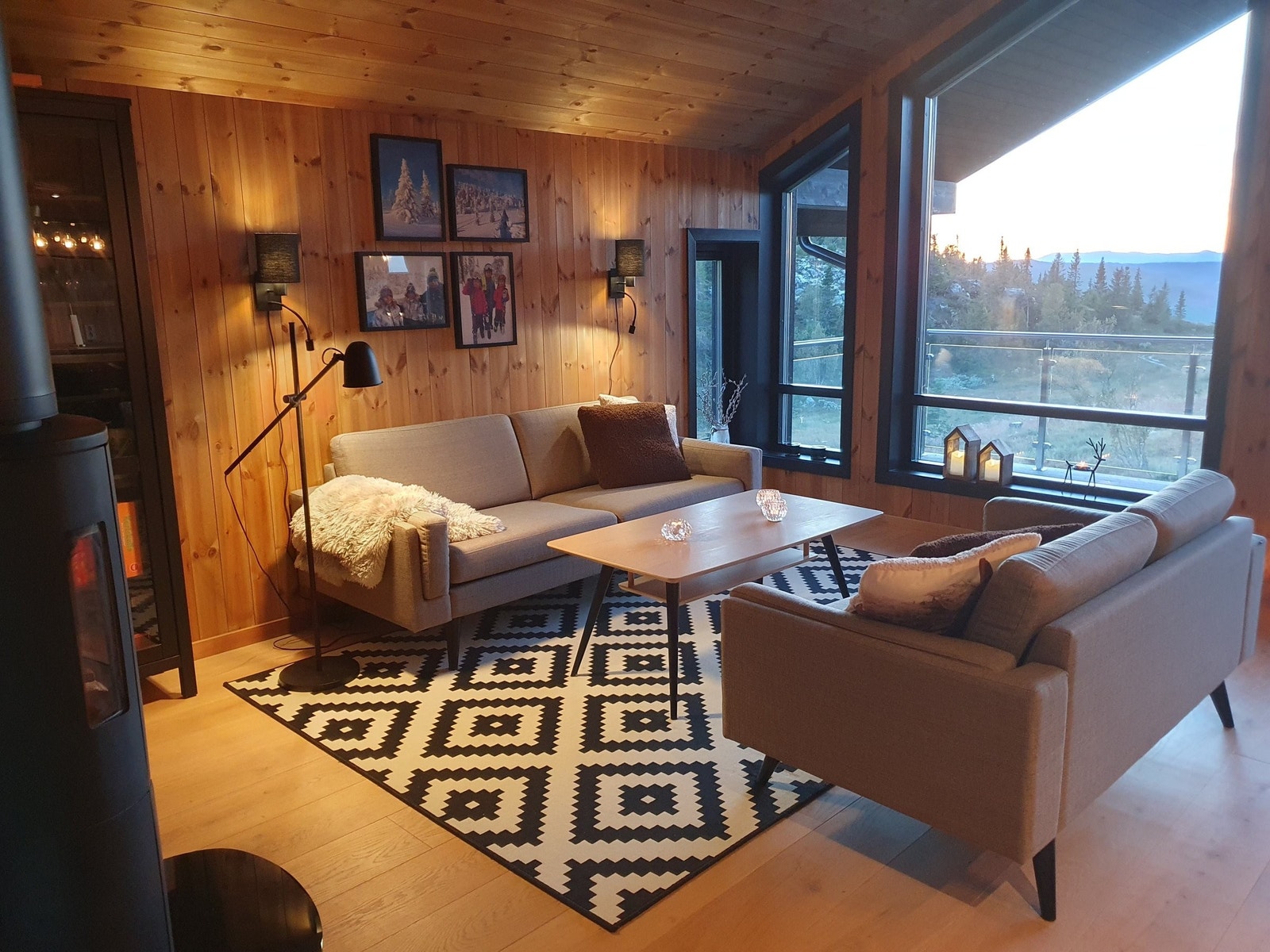 Lun og koselig hyttefølelse. Stue med peis og store vinduer med flott utsikt. Galleribilde