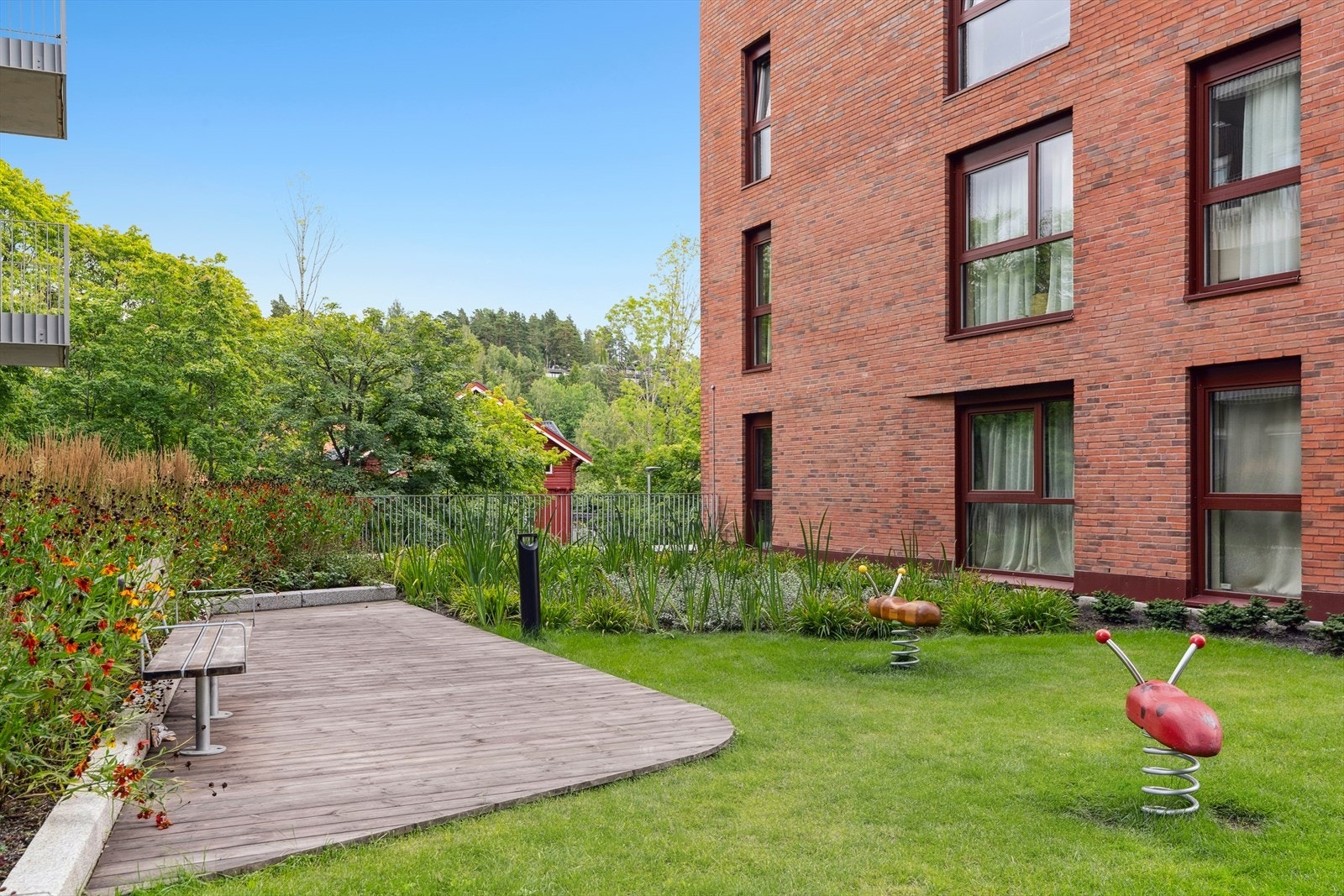 Fellesarealene er opparbeidet med plen, benker og platting samt lekeplass for barna. Galleribilde