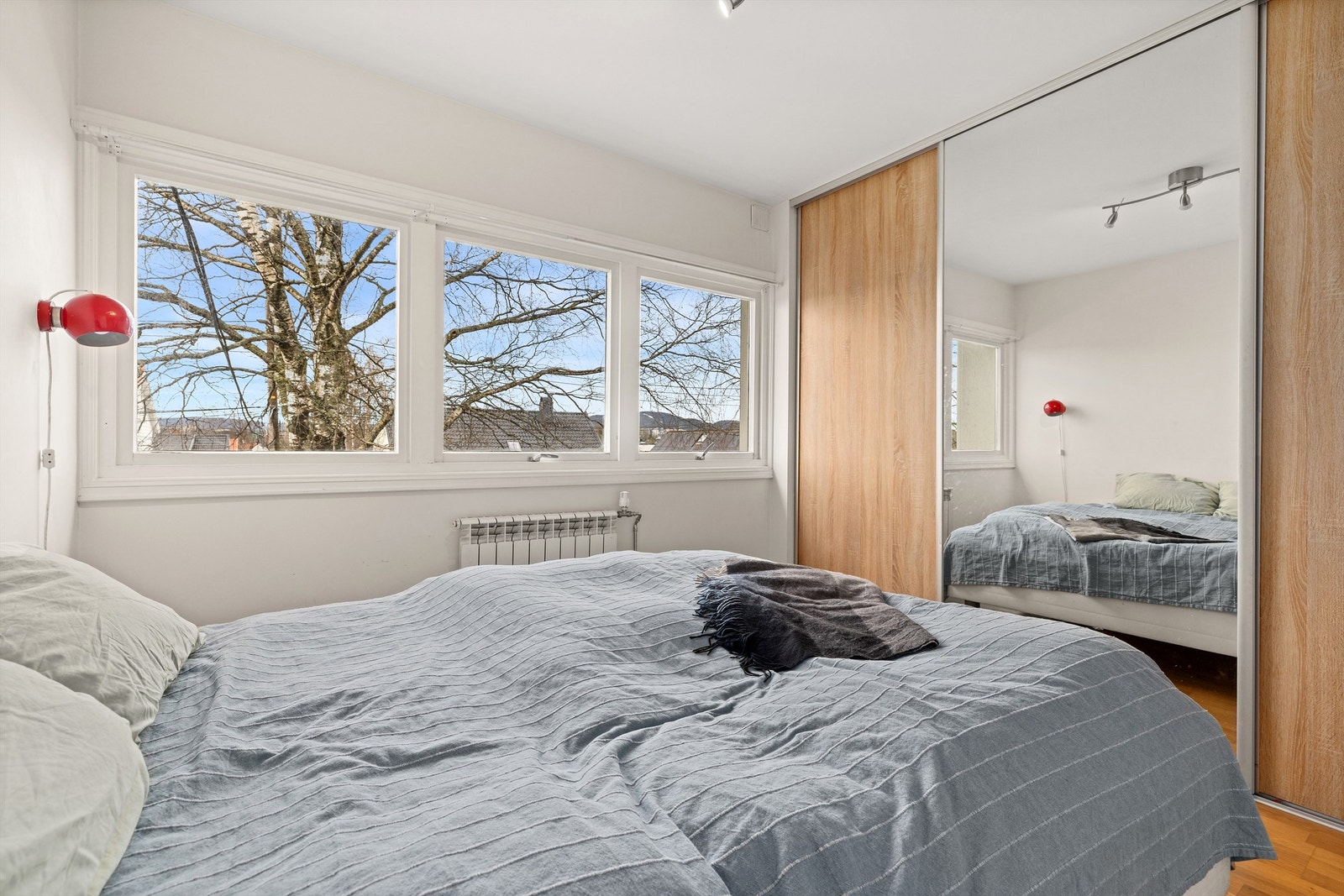 En romslig skyvedørsgarderobe med speilfronter gir rikelig med lagringsplass. Galleribilde