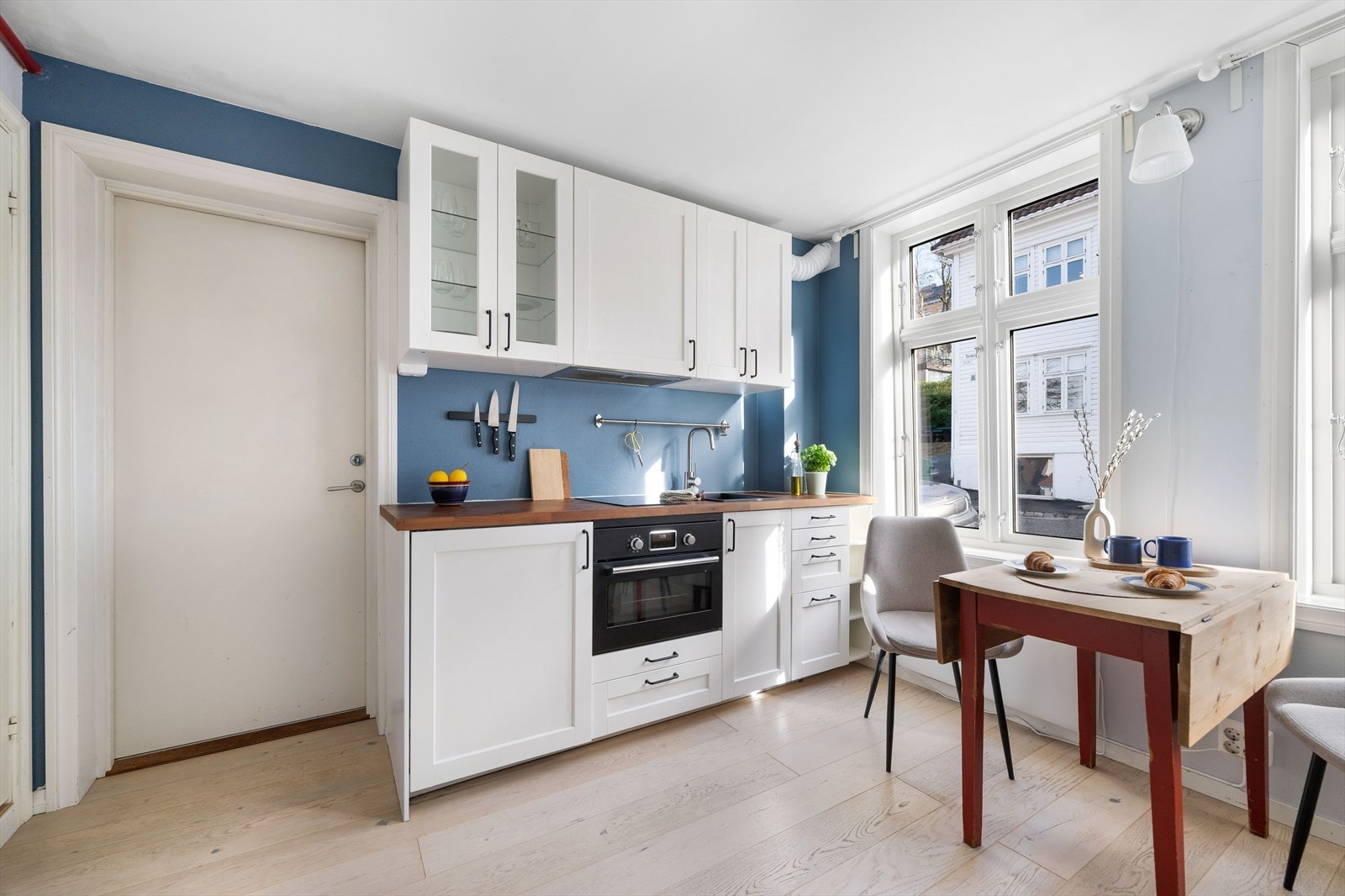 Kjøkkeninnredning med hvite profilerte fronter og laminat benkeplate med nedfelt vask. Galleribilde