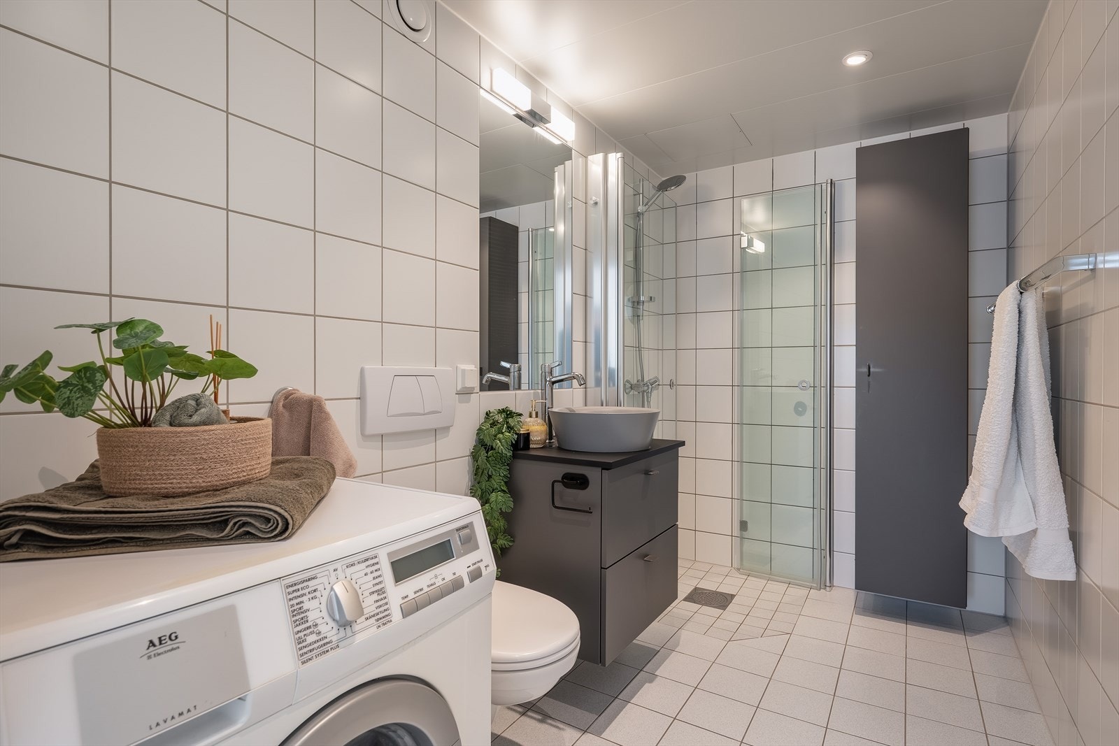 Pent og tidløst bad av god størrelse med varmekabler i gulv. Servantskap, høyskap og dusjdører ble fornyet i 2020, og gir badet et moderne og oppdatert uttrykk. Galleribilde