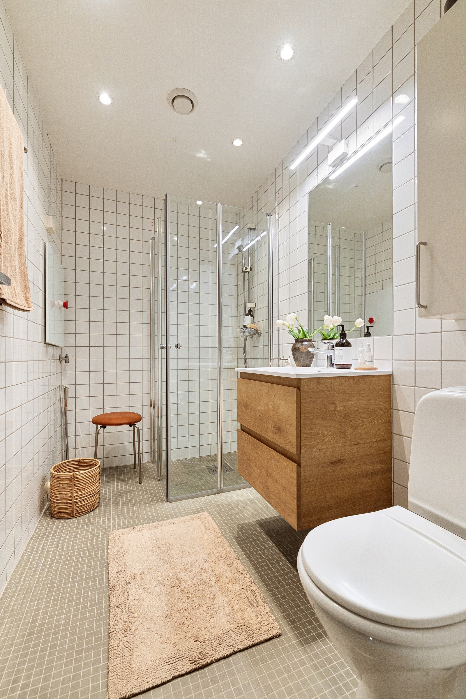Badet er utstyrt med opplegg for vaskemaskin, wc og dusjhjørne med folbare glassdører og ettgreps krummet armatur Galleribilde