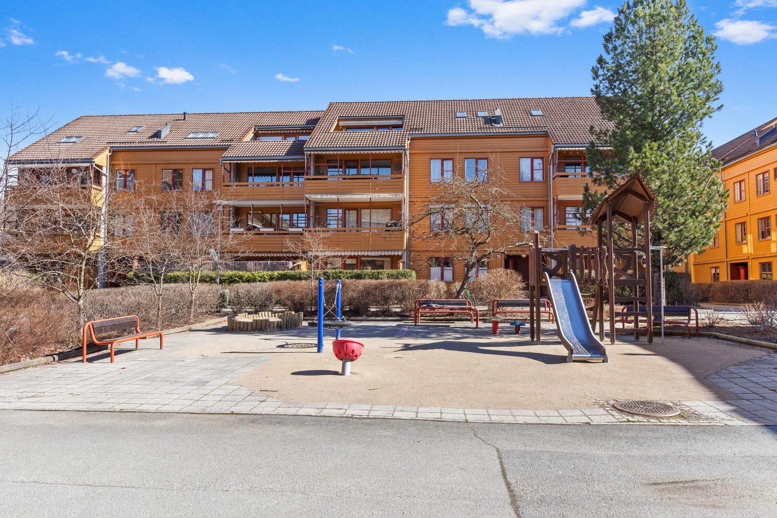 Hyggelig tun med lekeapparater og sittegrupper. Galleribilde