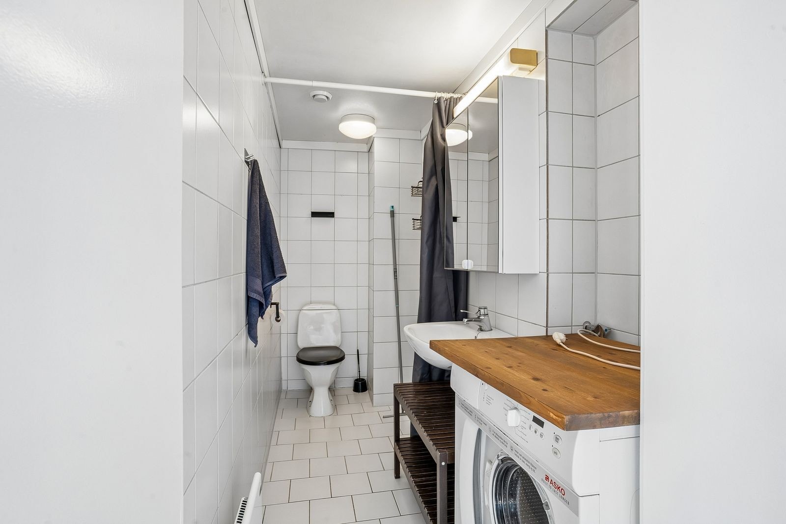 Flislagt bad med vaskemaskin. Galleribilde