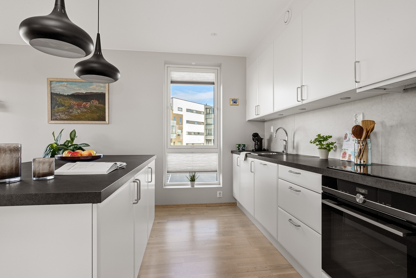 Innredningen har glatte fronter, laminert benkeplate og ventilator over kokesonen. Galleribilde