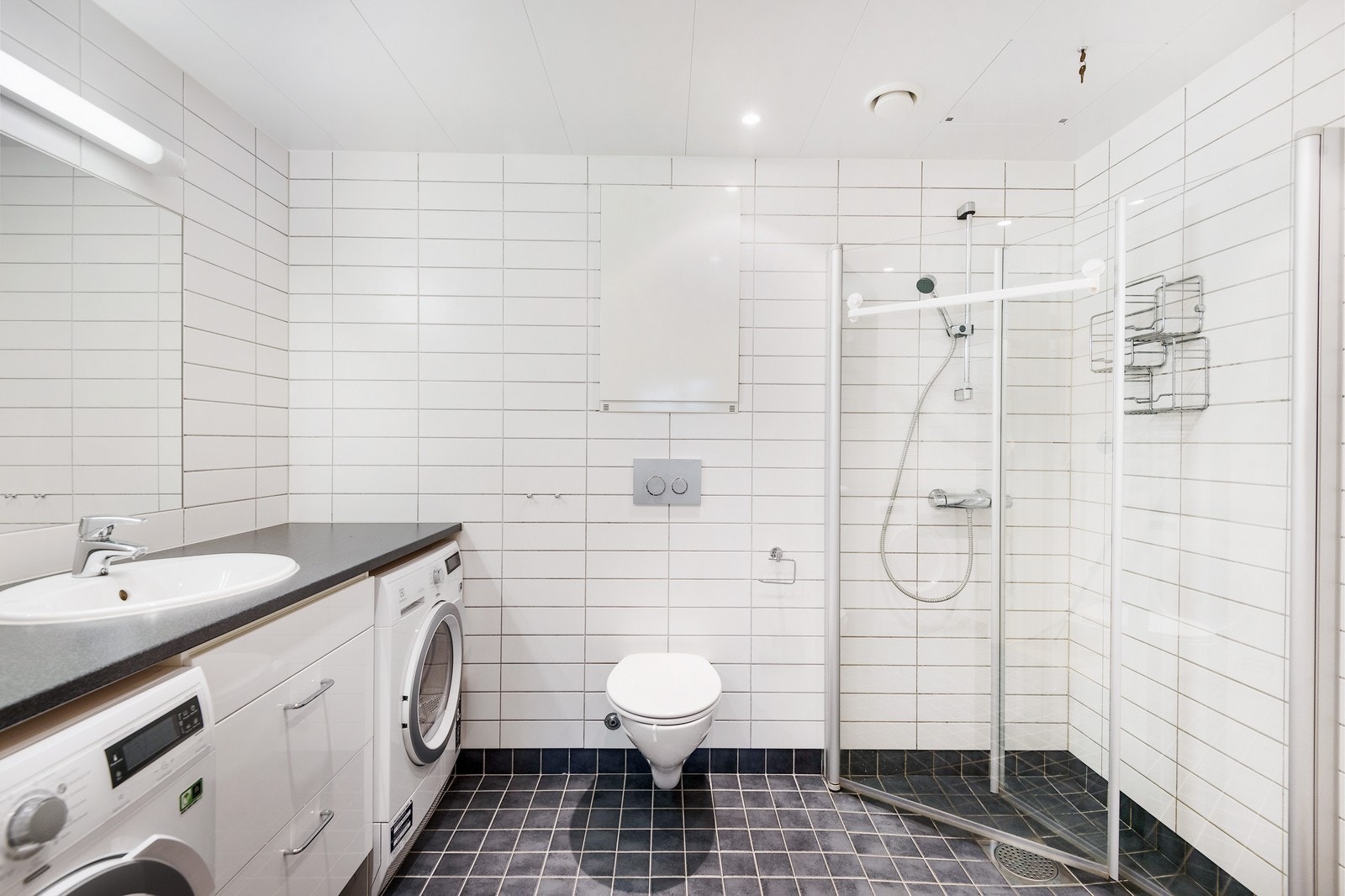 Flislagt bad med wc, servant og dusjhjørne med foldedører Galleribilde