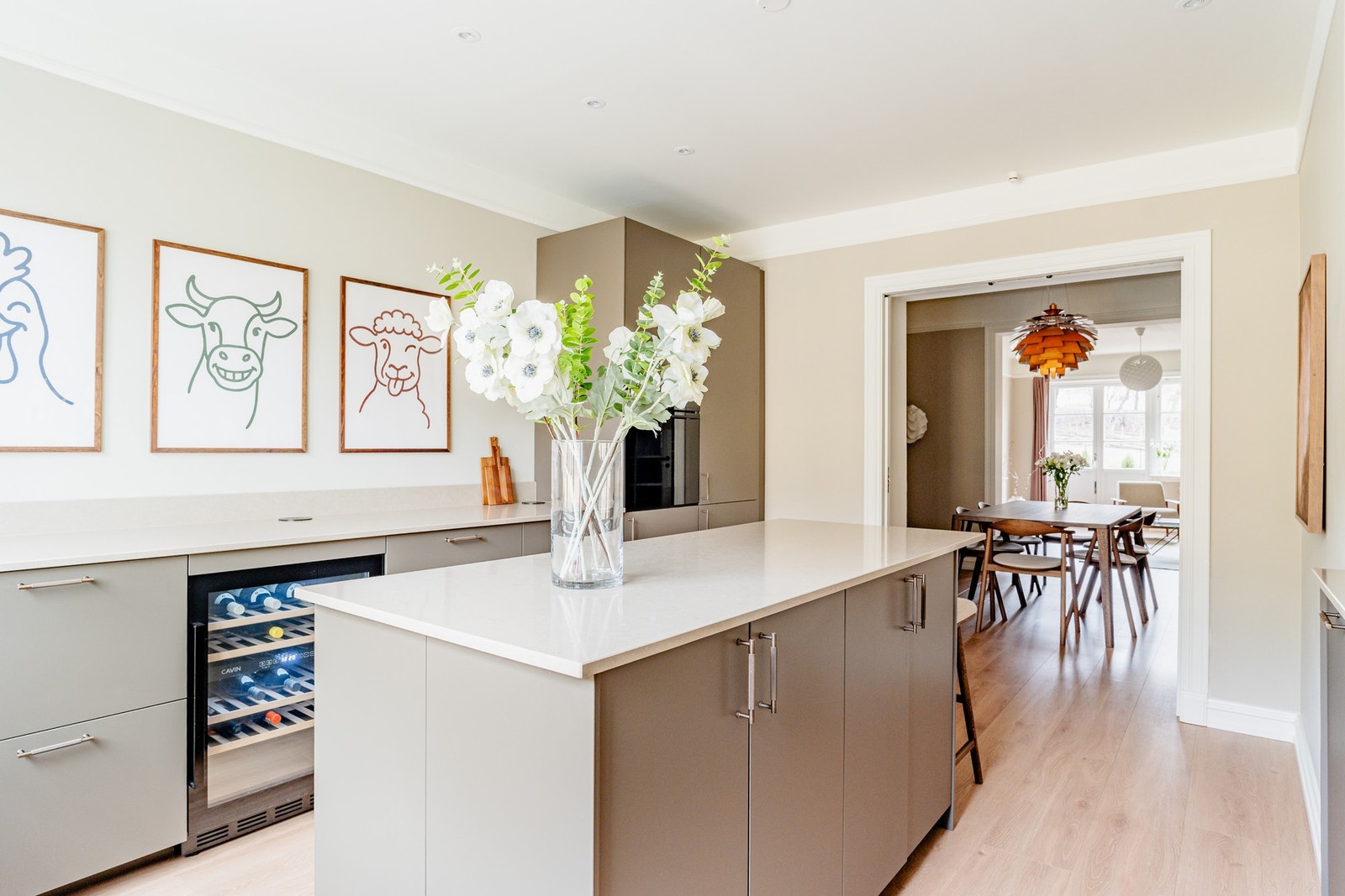 Kjøkkenets generøse størrelse gjør det til et perfekt sted for matlaging, med store benkeplater og skap for oppbevaring på begge sider, samt en stor og pen kjøkkenøy som inviterer til både matlaging og sosialt samvær. Galleribilde