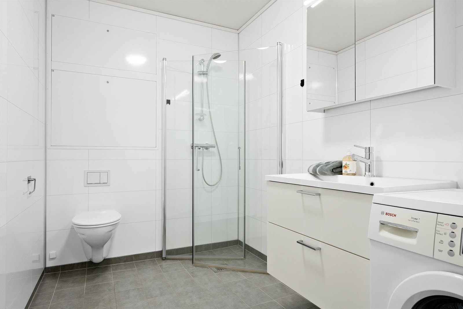 Badet har flislagt golv med vassboren golvvarme og vegghengt toalett. Her er det òg opplegg for vaskemaskin. Galleribilde