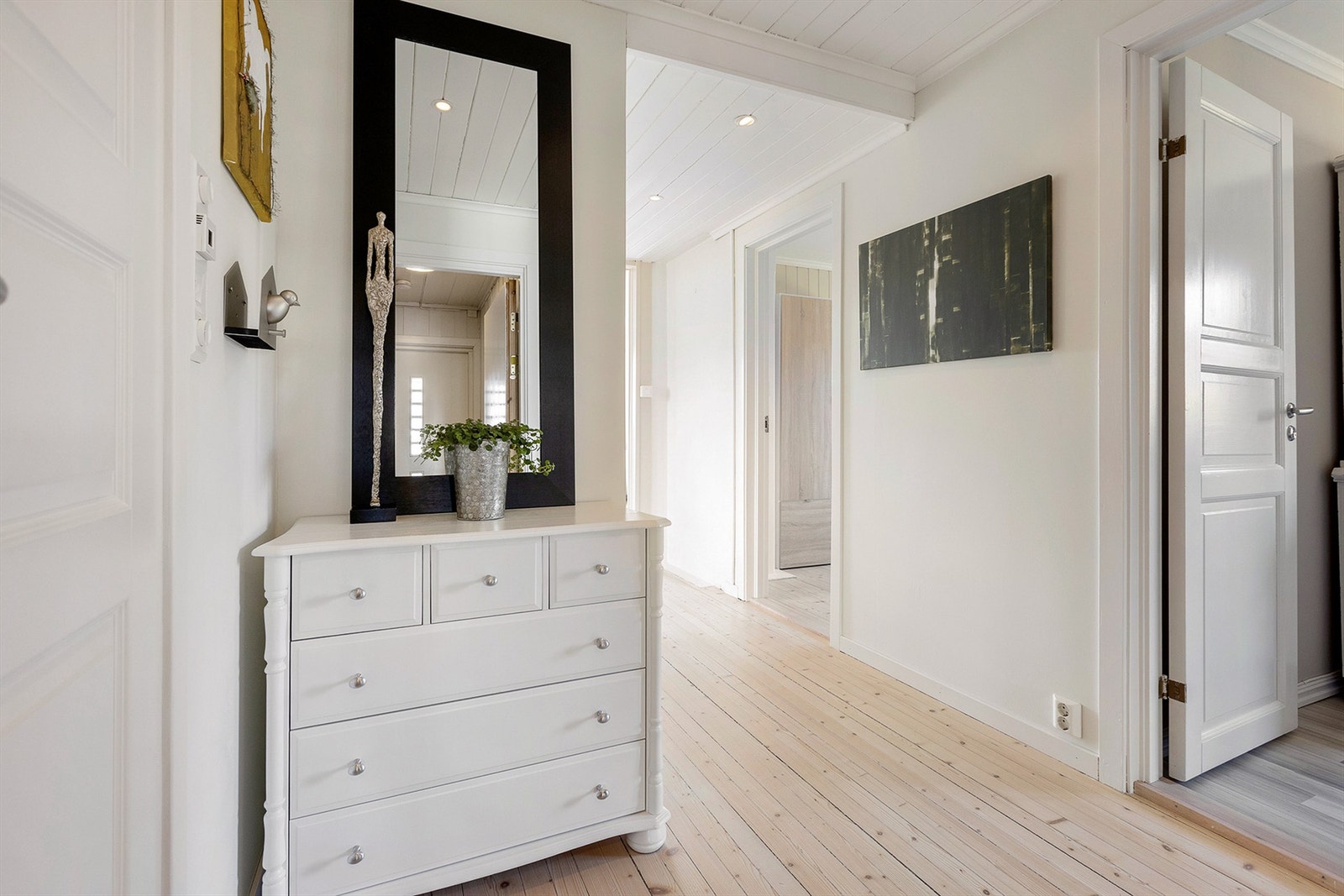 Velkommen inn inn i en lys og hyggelig entré med skyvedørsgarderobe Galleribilde