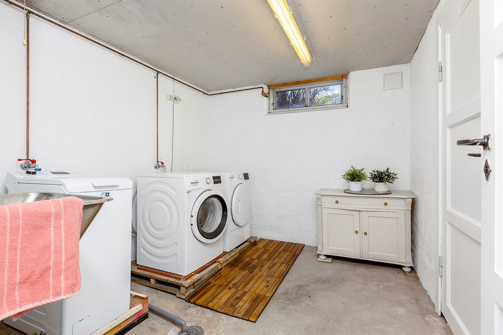 Man deler vaskerom i kjeller med den andre delen av tomannsboligen. Det er plass til egen vaskemaskin og tørketrommel i rommet. Galleribilde