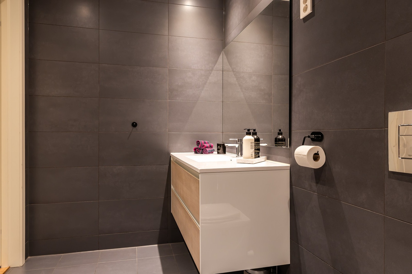 Badet fremstår moderne og stilrent med flislagte vegger og gulv. Galleribilde