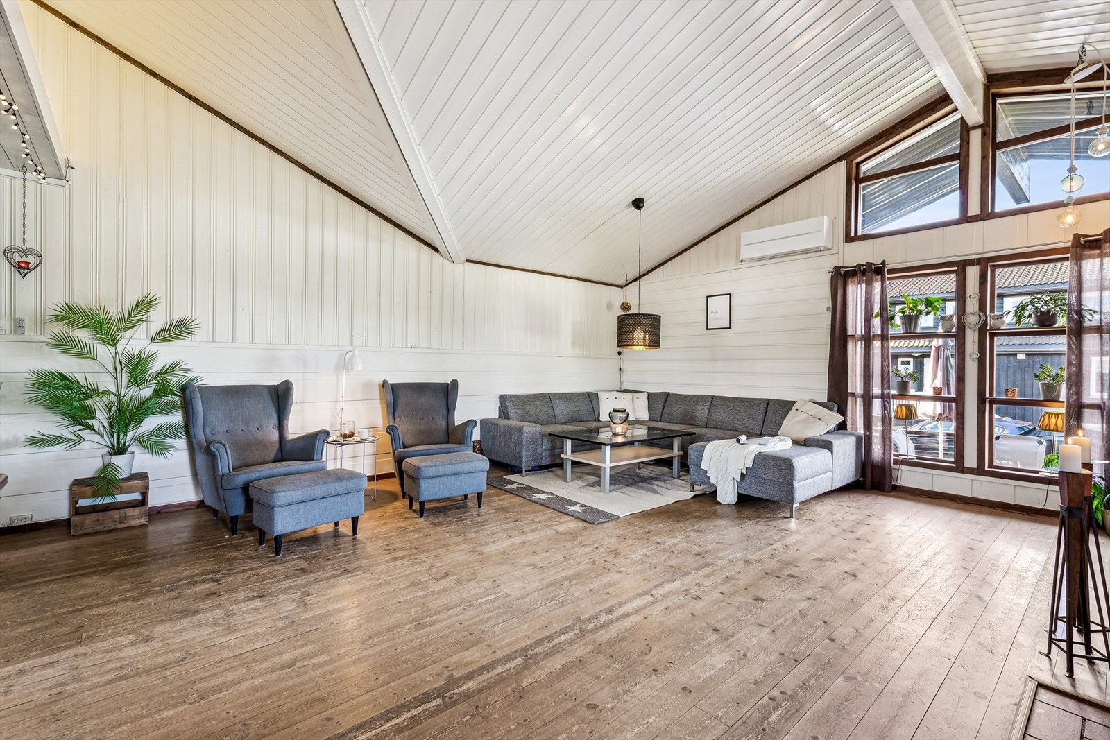 Stue med imponerende takhøyde og skråhimling gir en luftig og åpen atmosfære. Galleribilde