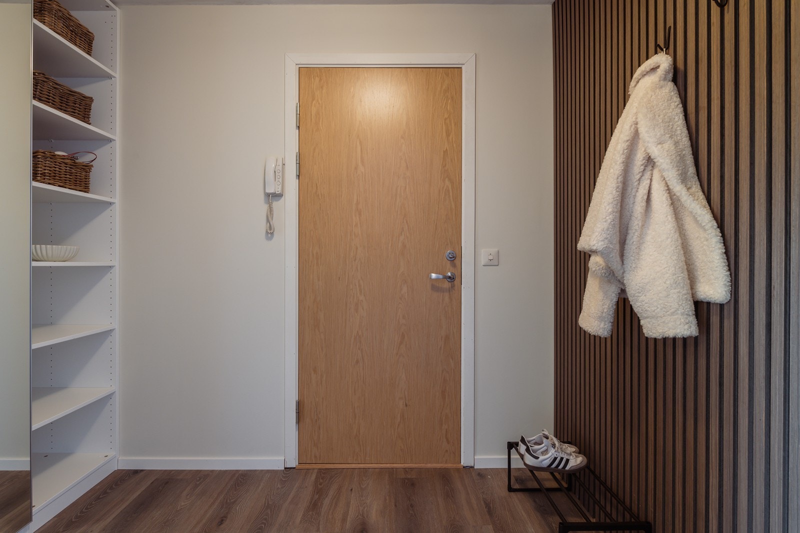 Velkommen inn! I entréen har man god plass til å henge fra seg jakker og sette fra seg sko. Entreen gir et godt førsteinntrykk av leiligheten. Det er skyvedørsgarderobe for ekstra oppbevaring - perfekt for sesongbaserte klær. Galleribilde