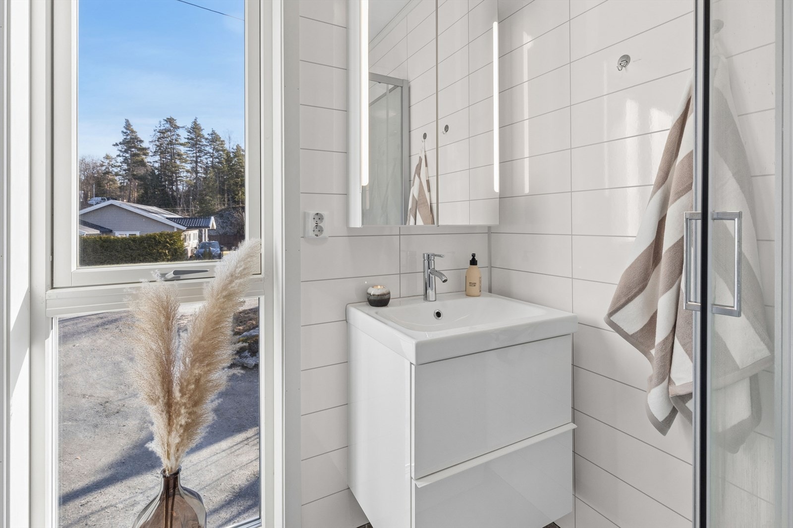 Bad i 2. etasje med innredning som består av en heldekkende servant med skuffer, skap og speil med integrert belysning. Galleribilde