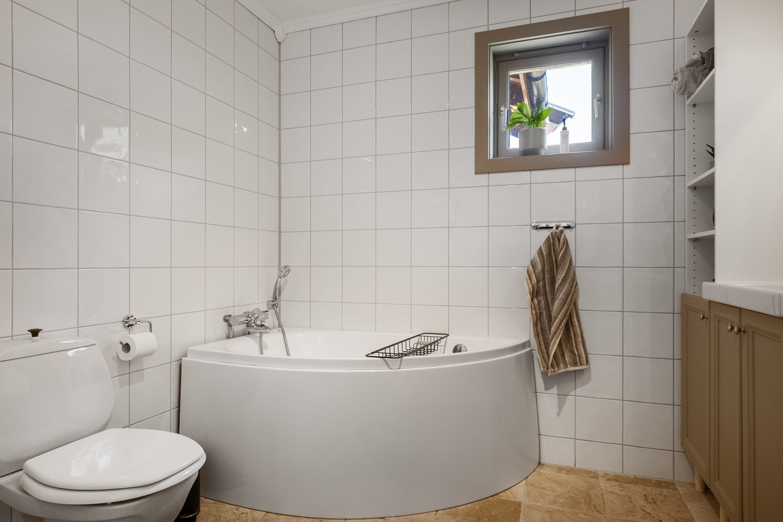 Badet er innredet med servantskap med to servanter, gulvmontert toalett og badekar med veggmontert armatur. Galleribilde