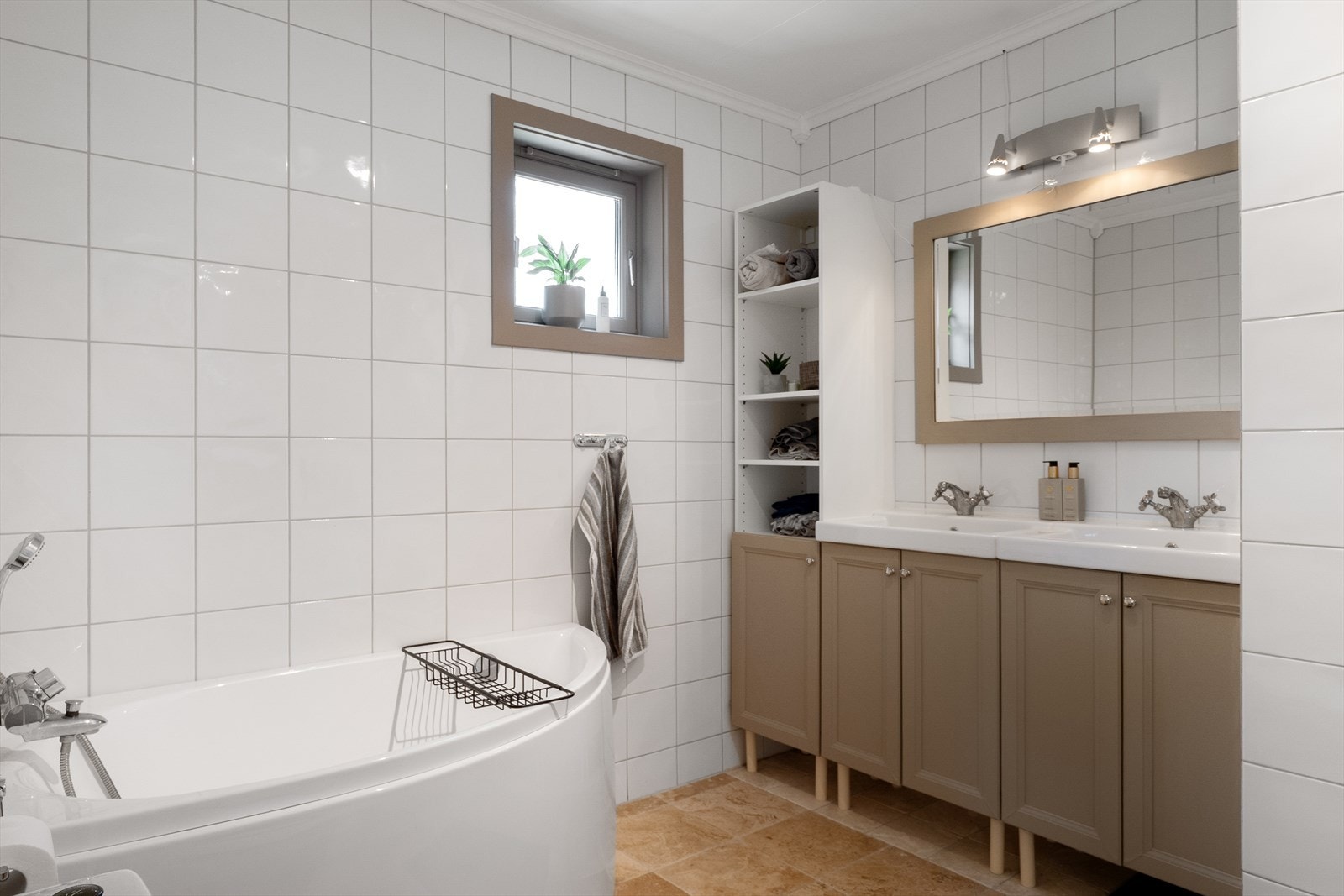 Baderommet i hovedetasjen er lyst og pent med fliser på gulv og vegger, samt malte plater i himling. Galleribilde
