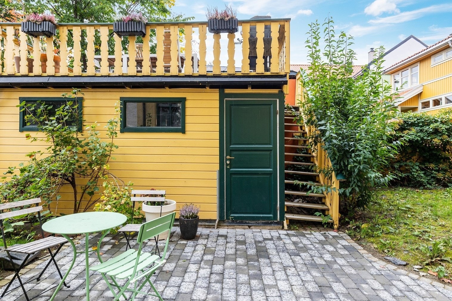 Bakgården er pent opparbeidet med beleggingstein, gressplen og diverse beplantning. Galleribilde