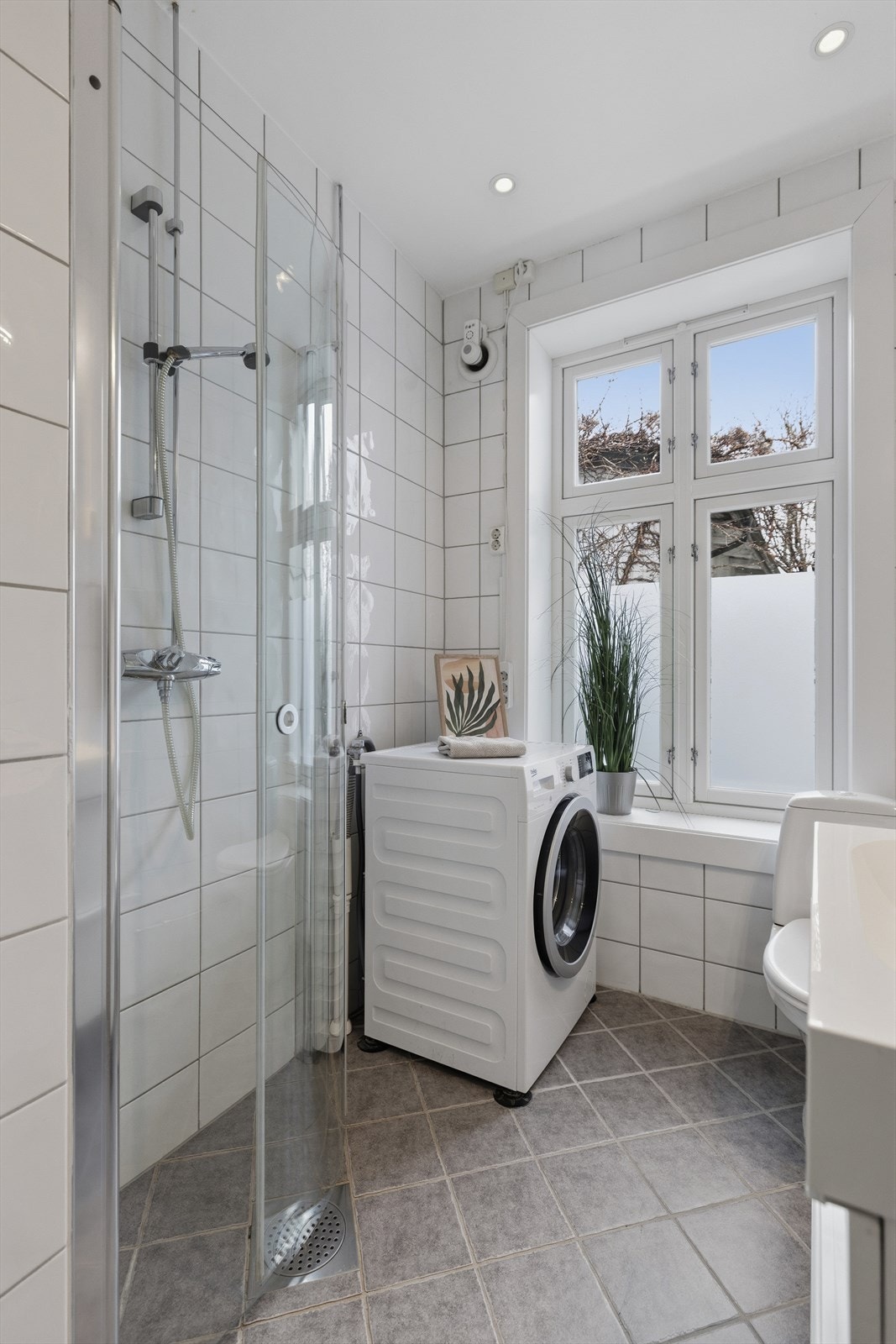 Badet er innredet med servant, speil, toalett og dusjhjørne. Galleribilde