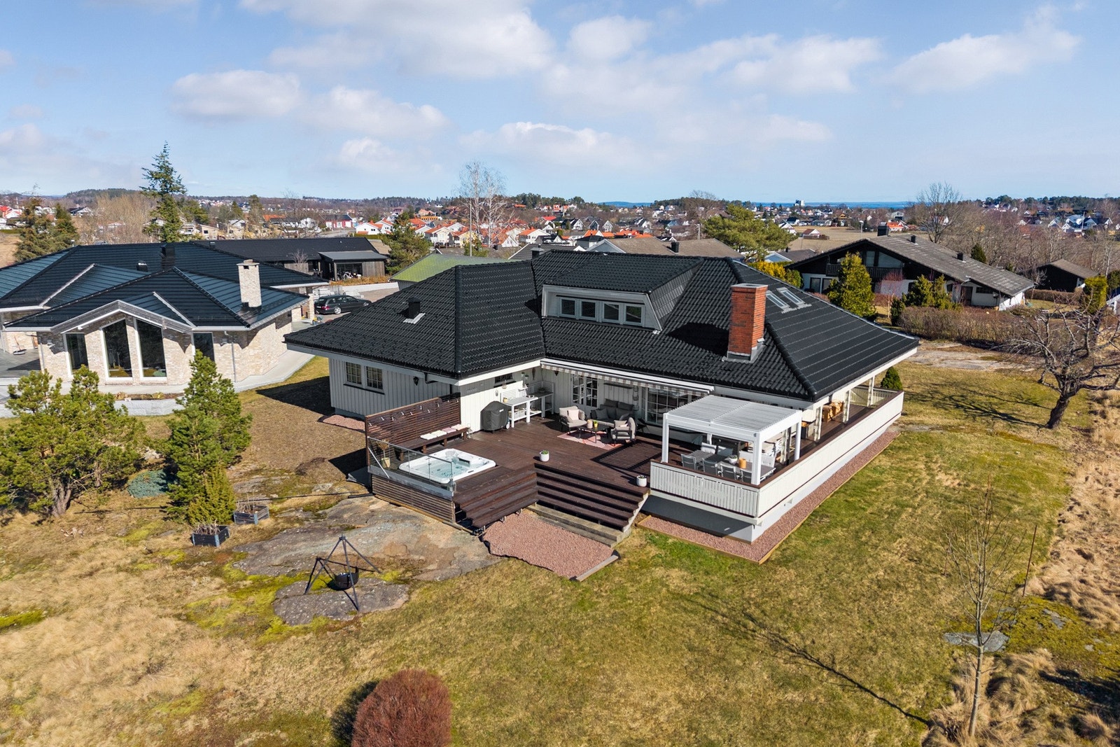 Tomten rundt boligen er pent opparbeidet med gressplen, trær, busker og naturlige fjellknauser som gir et variert og hyggelig uteområde. Galleribilde