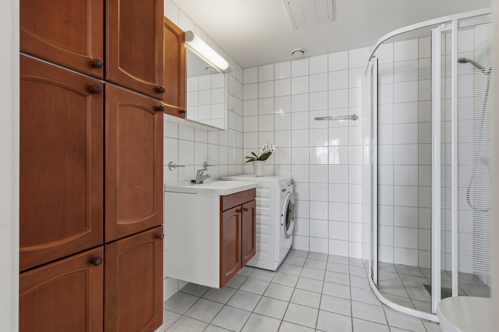Badet er innredet med flislagte vegger og gulv, samt slette overflater i himlingen Galleribilde
