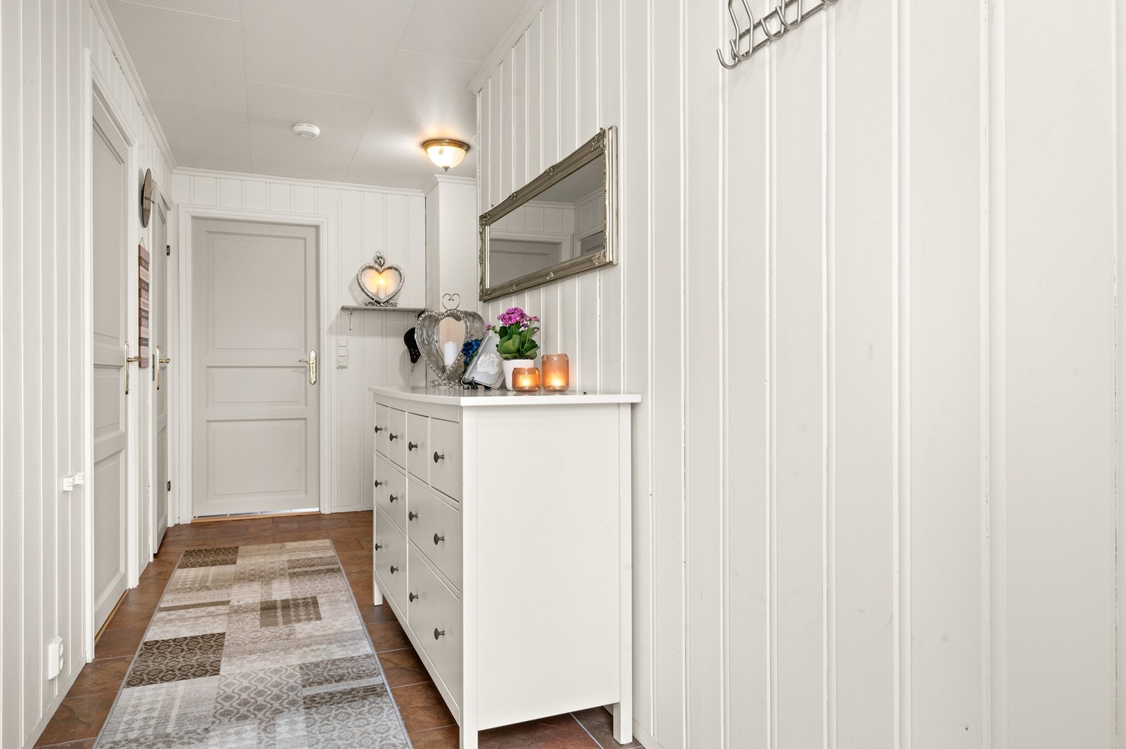 Velkommen inn! Den innbydende gangen har lyse panelvegger og god plass til oppbevaring. Galleribilde