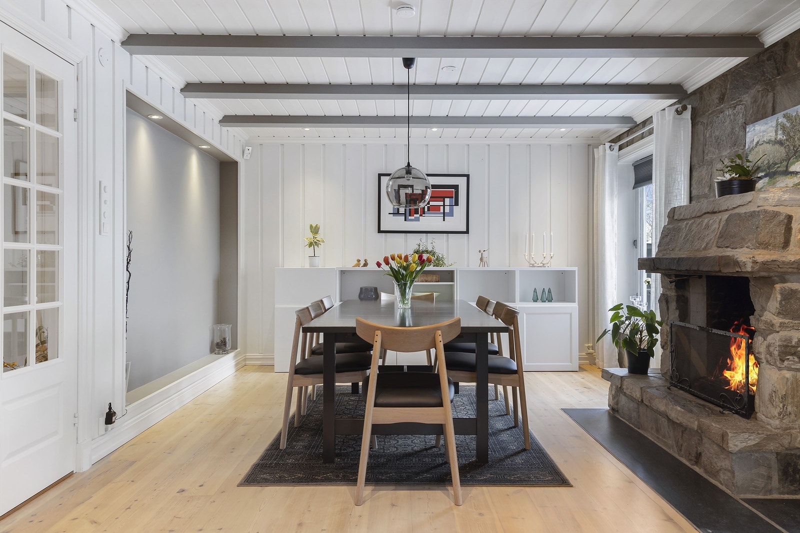 I stuen er det en innbydende murt peis og en effektiv peisovn som gir god varme Galleribilde
