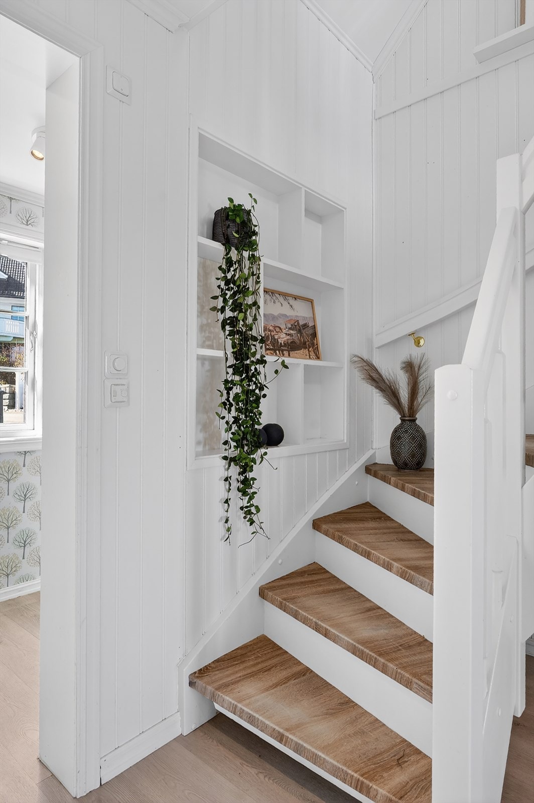 I hallen er det trapp opp til loftsetasjen. Dekorativ, innfelt hylle med plass til pyntegjenstander. Galleribilde