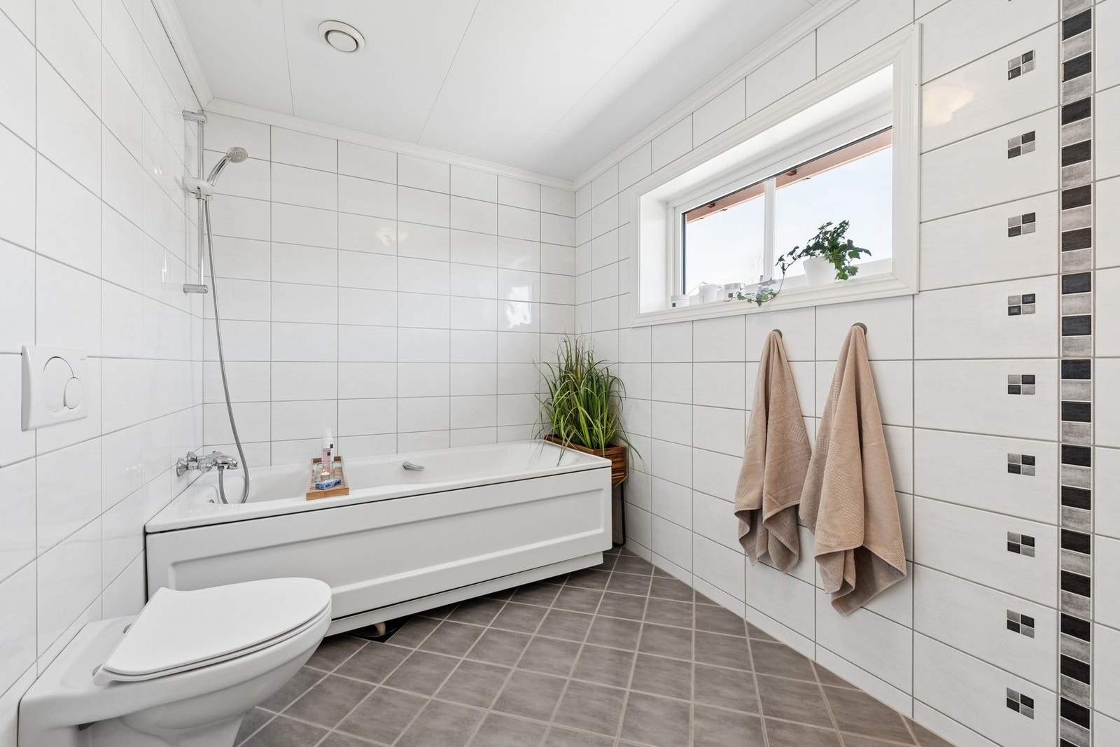 Badet i 2. etasje er romslig og lyst, med flislagte overflater og en praktisk planløsning. Galleribilde