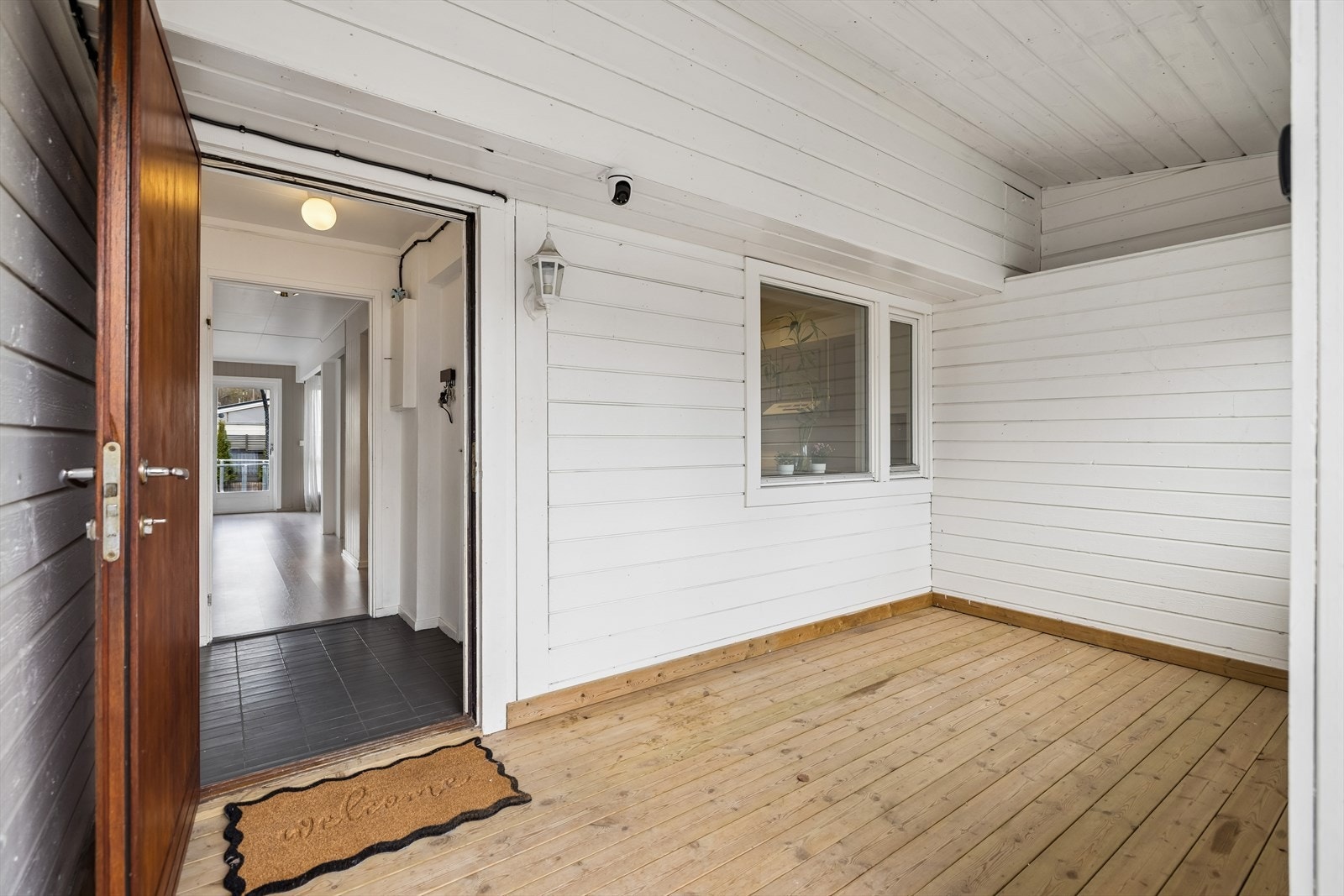 Overbygget inngangsparti som leder inn til boligens vindfang. Galleribilde