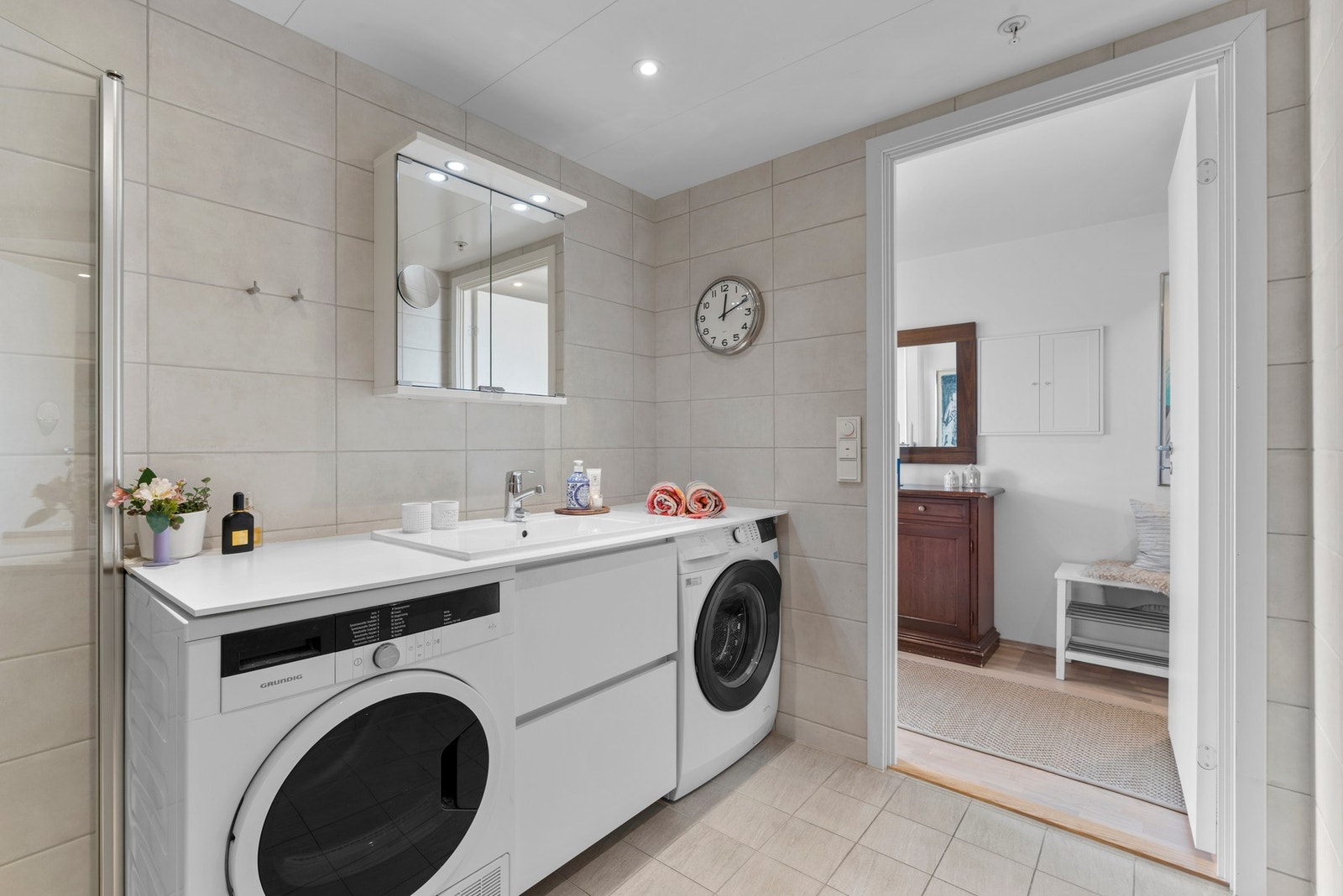 Badet ved entréen er utstyrt med dusjhjørne, veggmontert toalett og opplegg for vaskemaskin og tørketrommel. Galleribilde