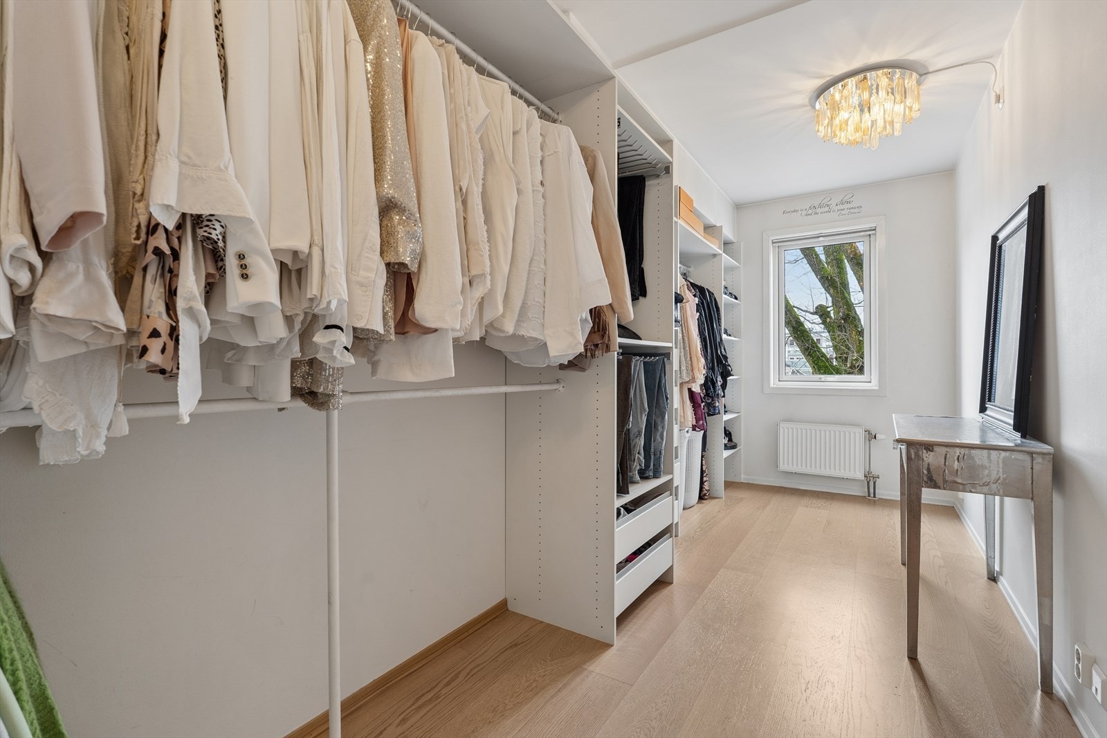 Garderobeløsning med skyvedører gir effektiv oppbevaring i omkledningsrommet. Malte vegger og parkettgulv gir et ryddig inntrykk i rommet. Dette er opprinnelig et soverom. Galleribilde