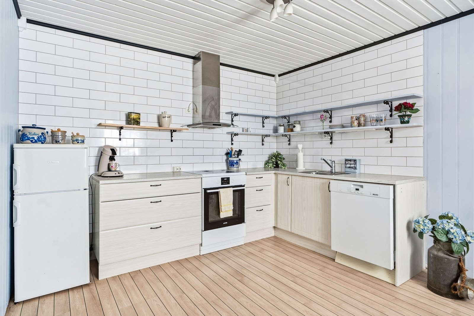 Kjøkkenet er lyst og har frittstående hvitevarer. Det er glatte fronter og benkeplate i laminat. Galleribilde