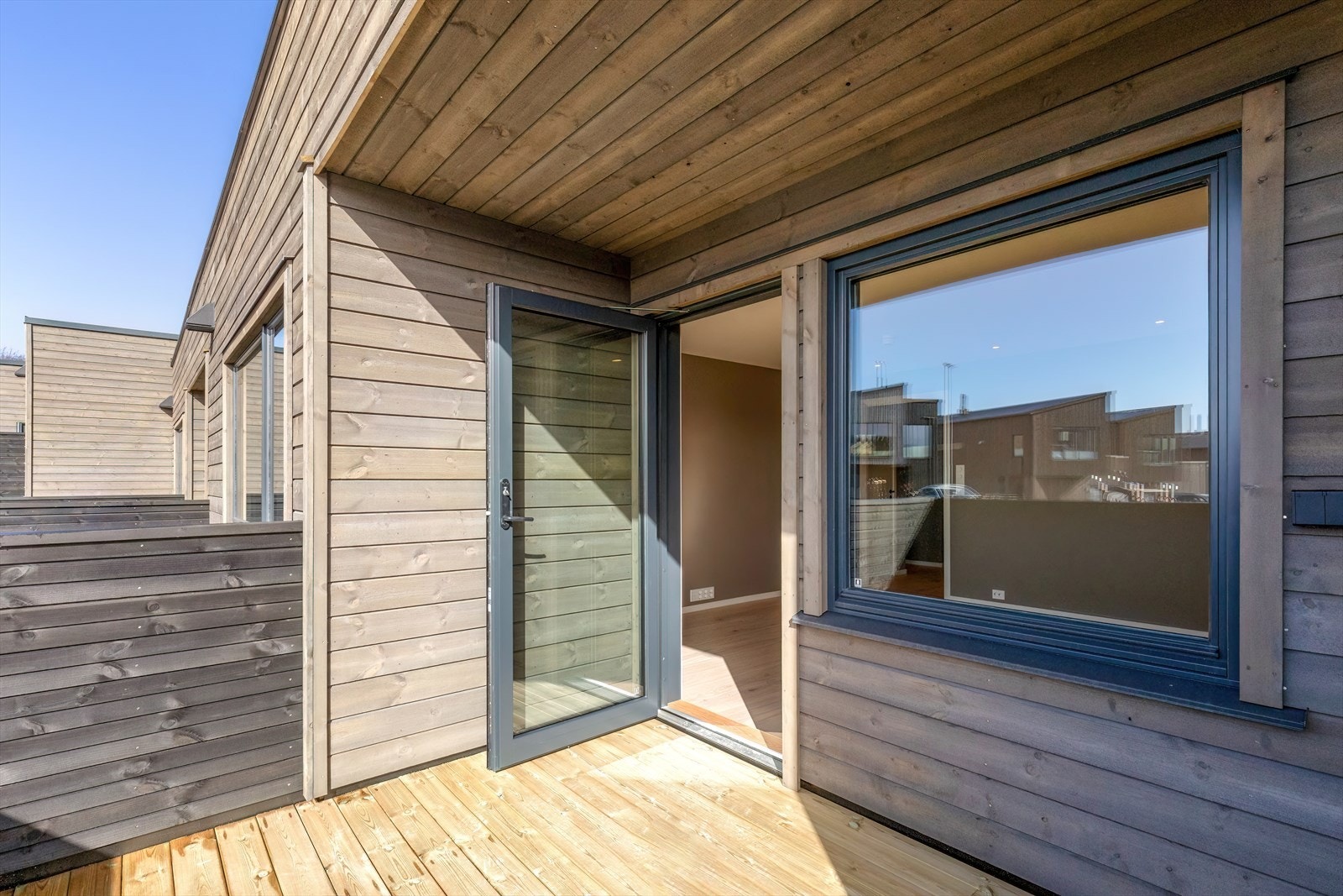 Fra stuen er det direkte tilgang til verandaen via en glassdør, som gir en naturlig overgang mellom inne og ute. Galleribilde