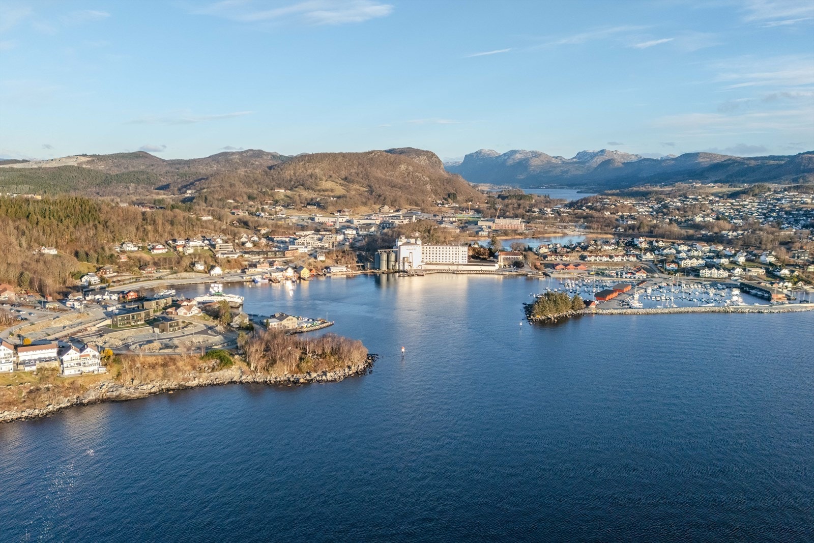 Oversiktsbilde av området viser nærhet til sjø og marina, omgitt av vakker natur og fjell. Galleribilde