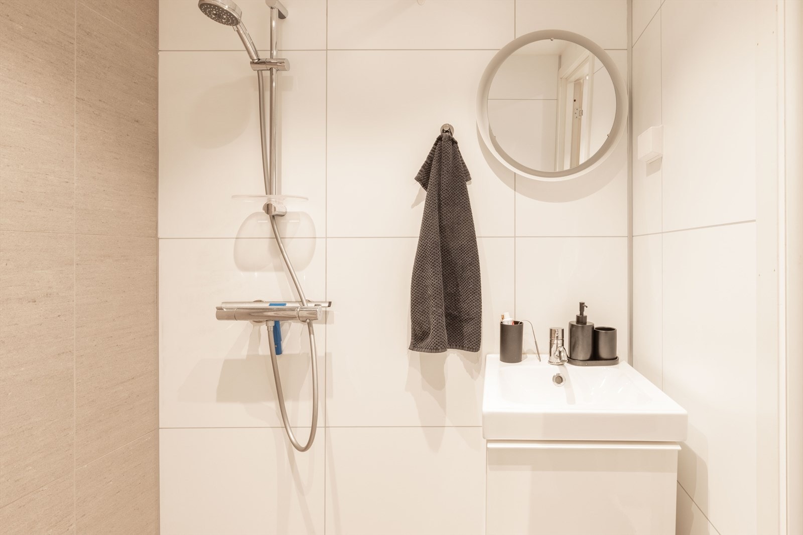 Underetasjen har eget bad, som er innredet med baderomsmøbel, heldekkende servant, speil med belysning, vegghengt toalett og dusjhjørne. Galleribilde