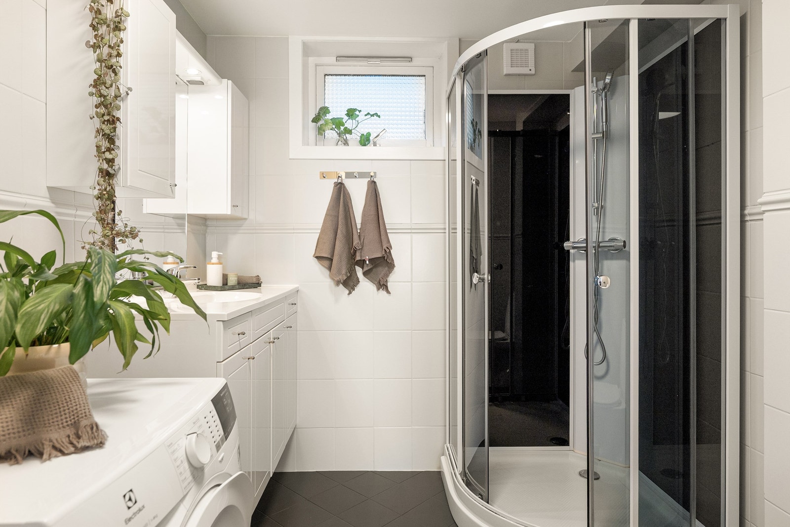 - Badet er innredet med dusjkabinett, toalett, vegghengt servant med oppbevaring og opplegg for vaskemaskin - Galleribilde