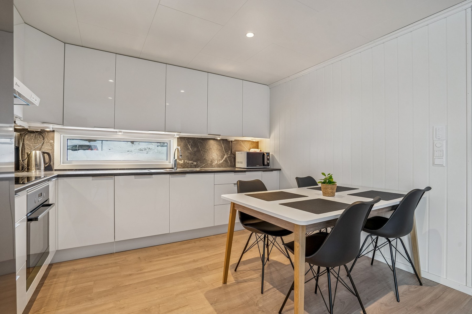 Kjøkkeninnredning med glatte fronter og laminat benkeplate. Galleribilde