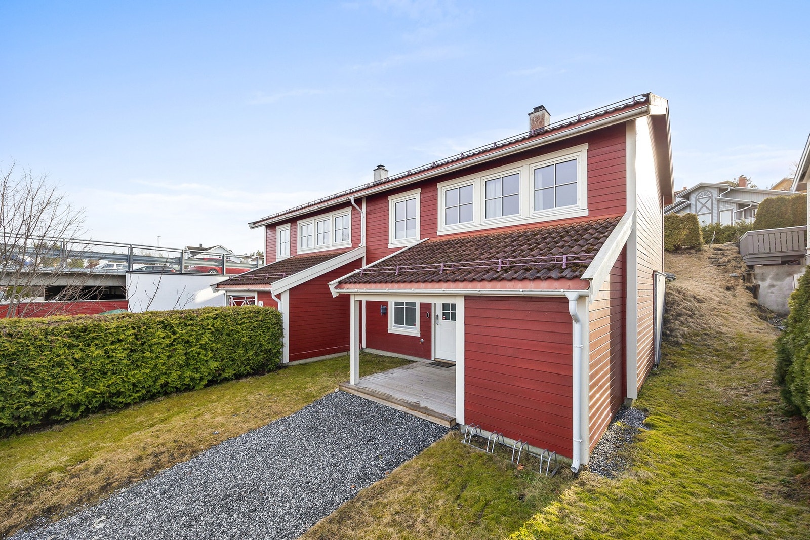 Gruslagt sti inn til huset. Overbygget inngangsparti og utendørs bod. Galleribilde