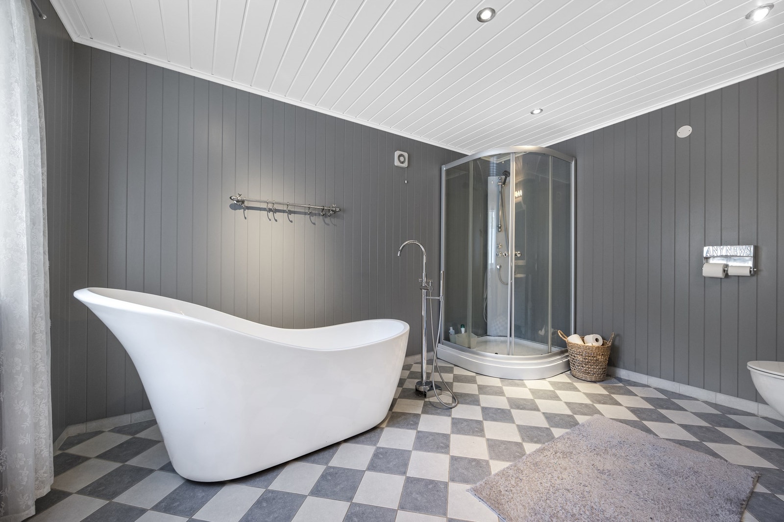 innbydende bad med flislagt gulv, dusjkabinett, badekar, gulvstående servantinnredning og toalett. Galleribilde