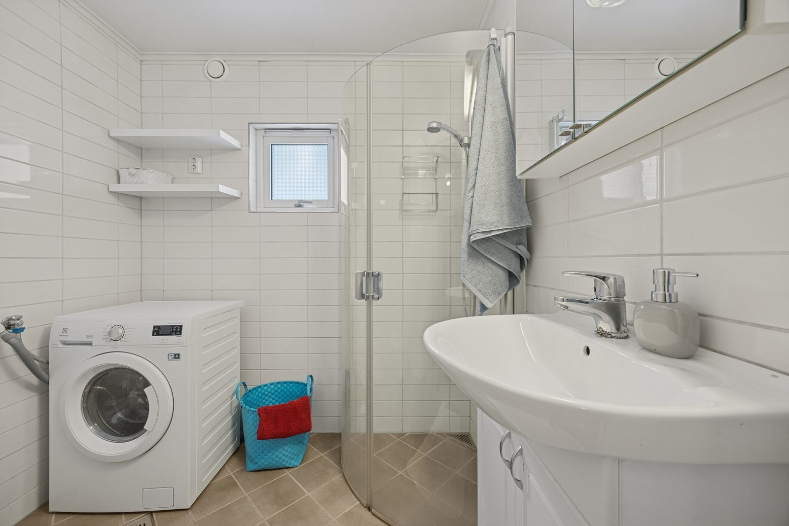 Pent, flislagt baderom med varmekabler. Det er elektrisk styrt vifte og naturlig ventilasjon gjennom ventil på yttervegg. Galleribilde