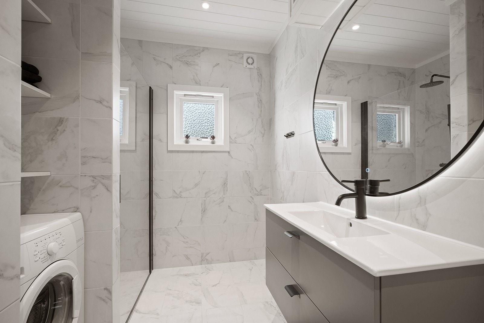 Badet inneholder wc, dusjhjørne og håndvask med speil og skuffer. Tilpassede hyller. Opplegg for vaskemaskin. Galleribilde