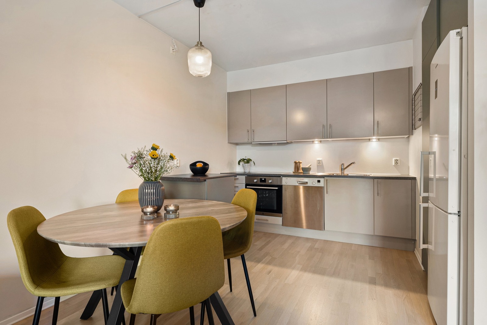 Åpen kjøkkenløsning med spiseplass og god arbeidsbenk - innredningen er fra byggeåret og fremstår pen og velholdt. Galleribilde