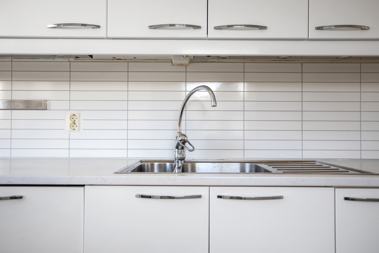 Laminert benkeplate med nedfelt utslagsvask og praktisk kitchenboard mellom over- og underskap. Galleribilde