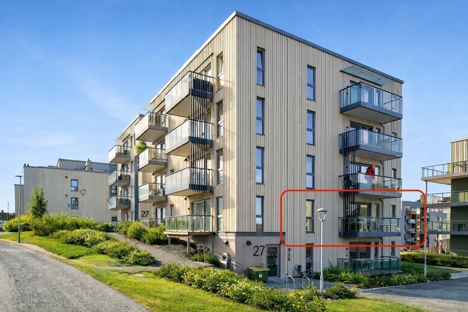 Fasadebilde som viser byggets plassering og leilighetens beliggenhet.
(Sommerillustrasjon av uteområdet. Snø er fjernet og vegetasjon er gjort grønnere. Bygg og leilighet er ikke endret.) Galleribilde