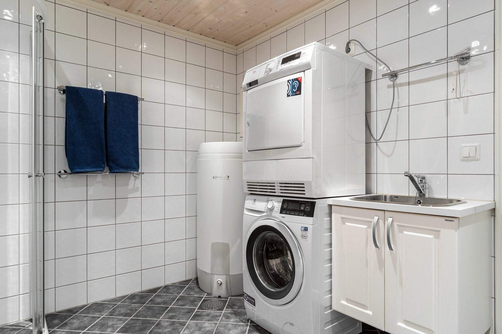 Praktisk løsning med dusj, toalett og opplegg for vaskemaskin. Galleribilde