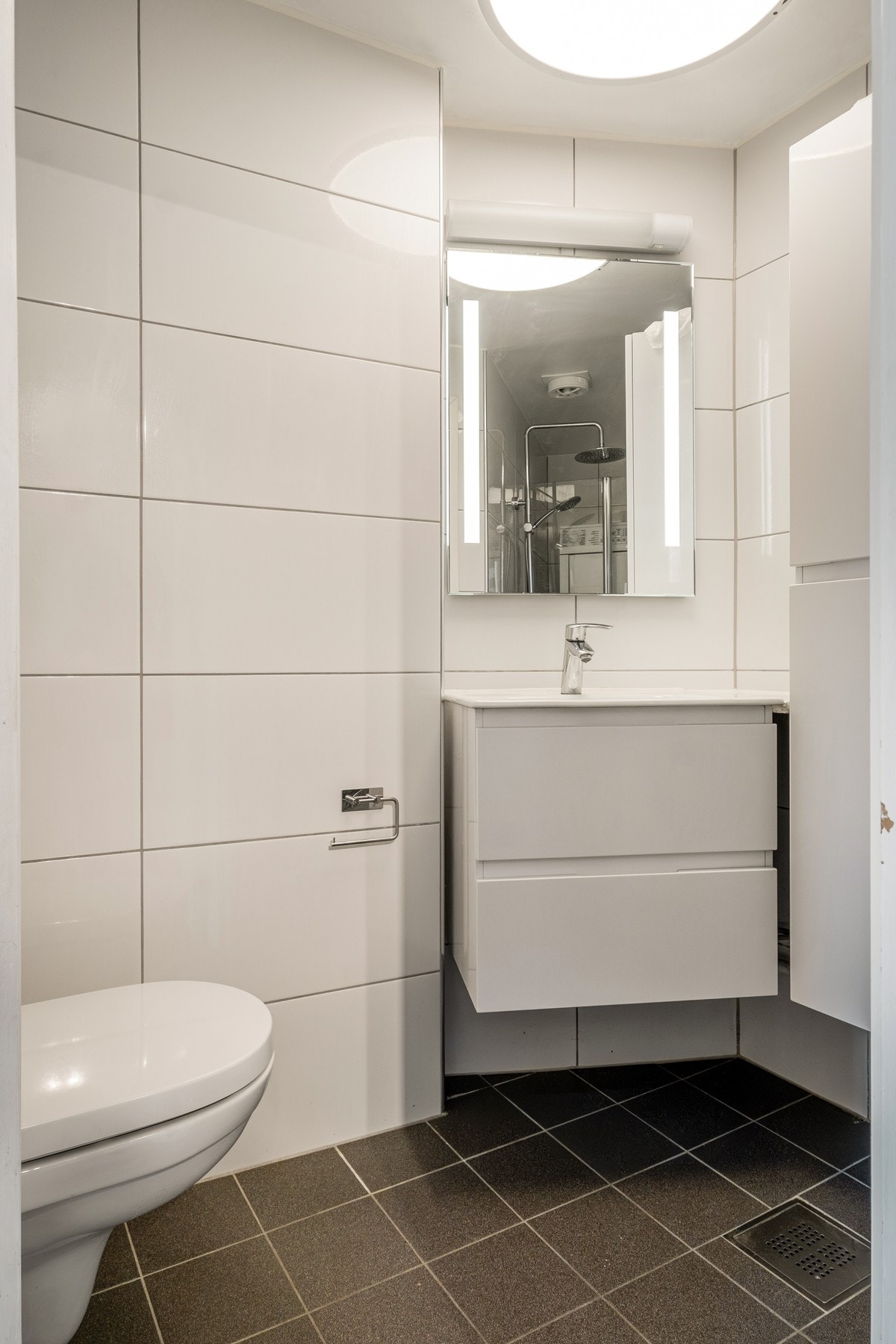 Badet er innredet med toalett, dusj, servant og opplegg for oppvaskmaskin og tørketrommel, samt elektrisk gulvvarme. Galleribilde