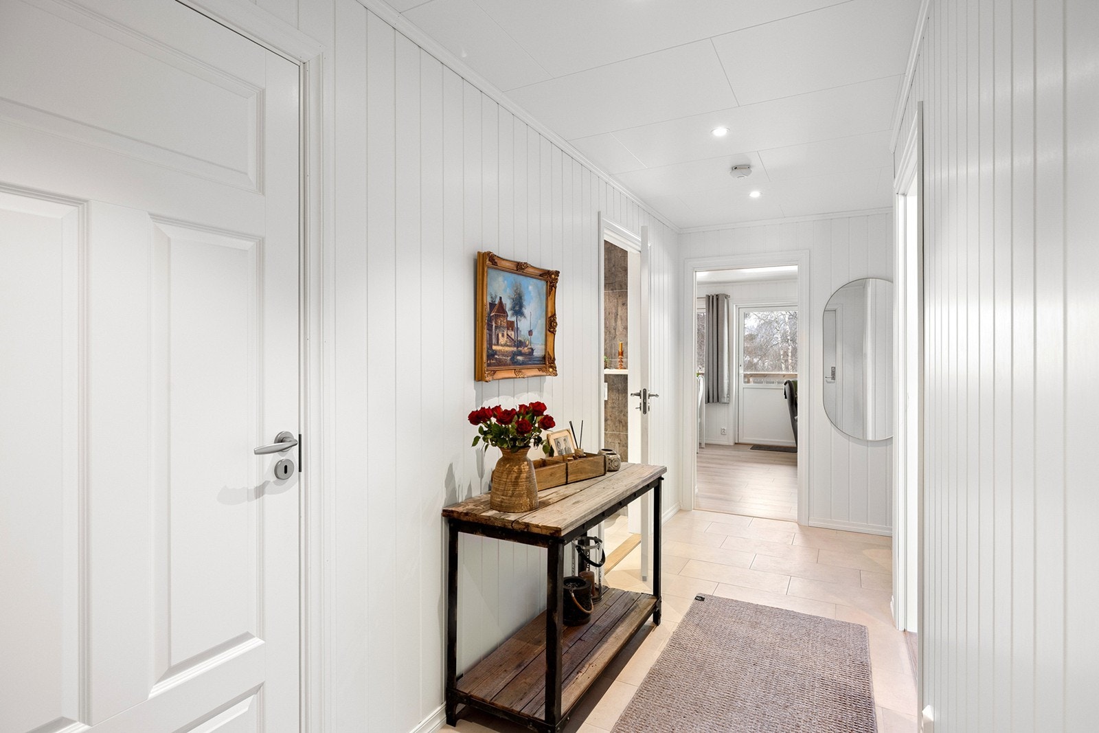 Lys og åpen entré med lyse flater og downlights i taket. Entréen har god plass til oppbevaring av ytterklær og sko. Galleribilde