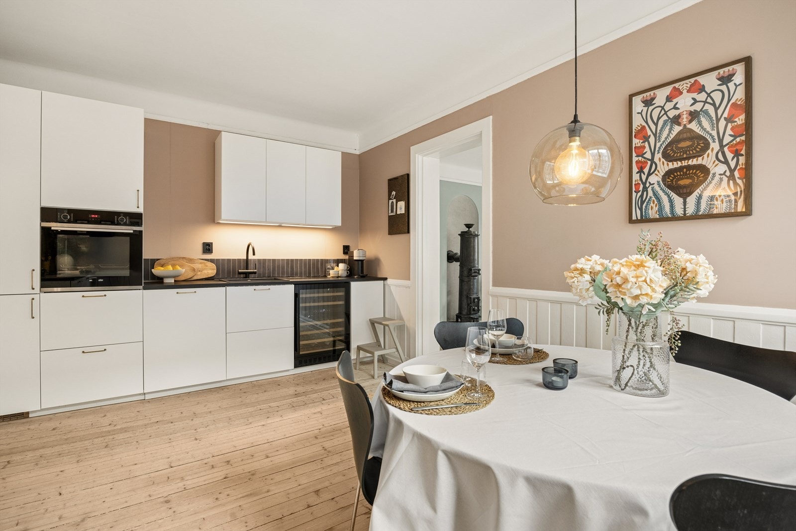 Kjøkkeninnredning med folierte skrog med slette fronter og en laminert benkeplate. Her kombineres moderne funksjonalitet med bygårdens originale sjarm. Galleribilde